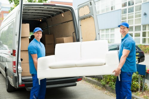 Removal team loading belongings safely with protective equipment