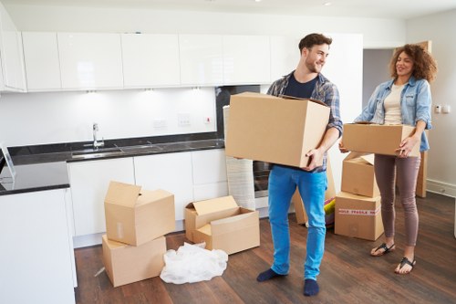 Removal team carrying boxes from a flat with stairs in Kentish Town